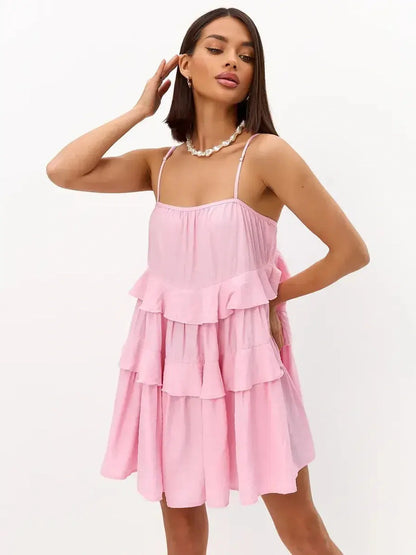 Breezy pink mini dress with ruffles and spaghetti straps, perfect for summer, weddings, and special occasions.
