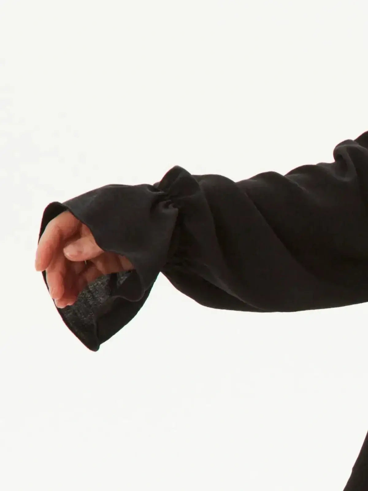 Close-up of ruffled black sleeve of the Ruffle Muse Set, showcasing modern feminine elegance in women’s clothing.