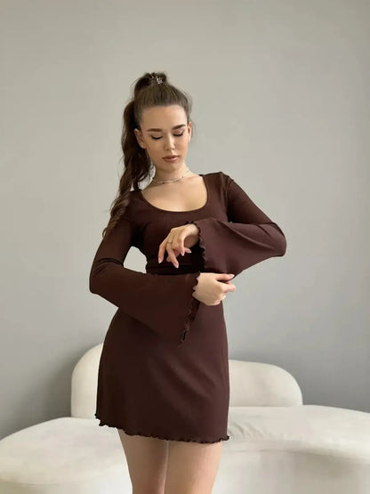 Model showcasing the Mocha Muse mini dress featuring long sleeves and a scoop neckline, perfect for stylish outings.