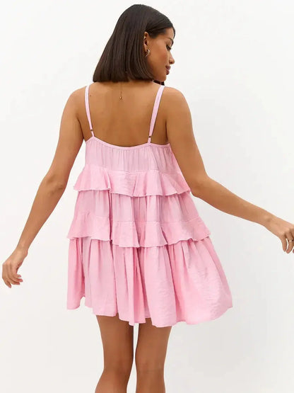 Back view of a pink mini dress with tiered ruffles and spaghetti straps, perfect for summer occasions.