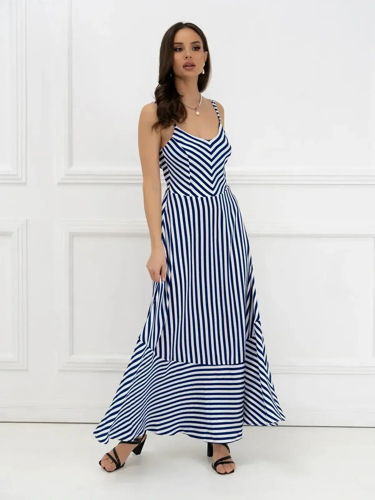Model wearing a Marina Stripe Maxi Dress featuring bold stripes and a flowing silhouette, perfect for summer occasions.