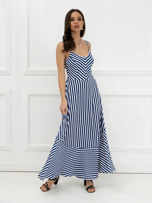 Model wearing a Marina Stripe Maxi Dress featuring bold stripes and a flowing silhouette, perfect for summer occasions.