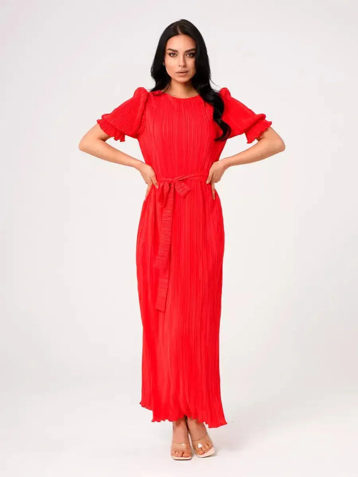 Model wearing the vibrant red Maxi Dress Solaria featuring pleated design and a belted waist.