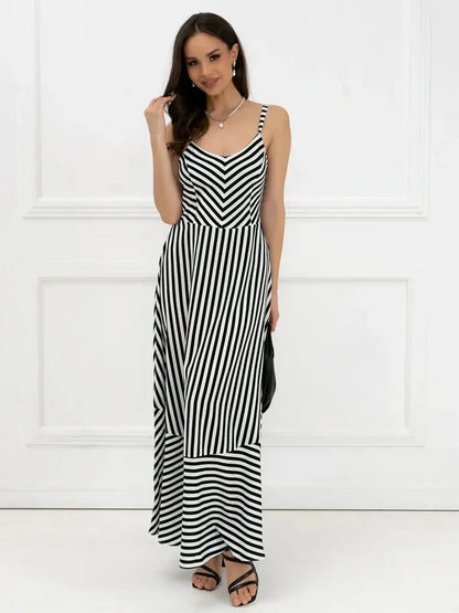 Woman in a black and white striped maxi dress with a fitted bodice, perfect for weddings and summer occasions.