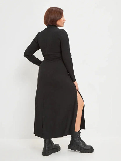 Back view of a black midi dress with side slit, styled with combat boots, showcasing modern elegance for women.