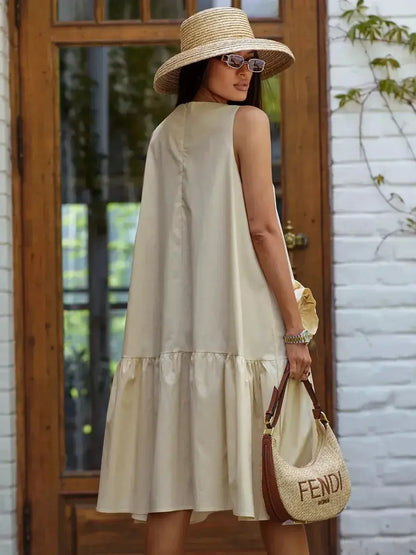 Charming midi dress in champagne, featuring a wide-tiered hem and summer accessories for warm-weather events.