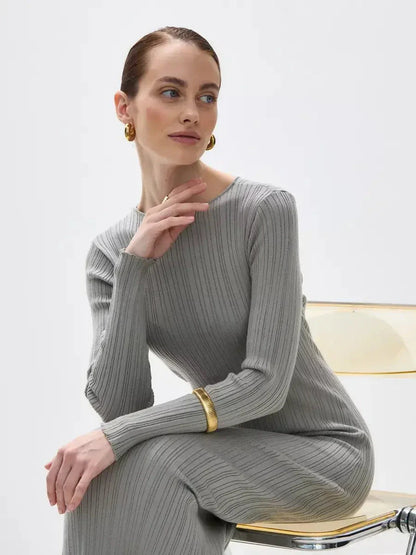 Model wearing the Sculpted Grace Maxi Dress in grey, showcasing ribbed elegance and a sculptural fit.