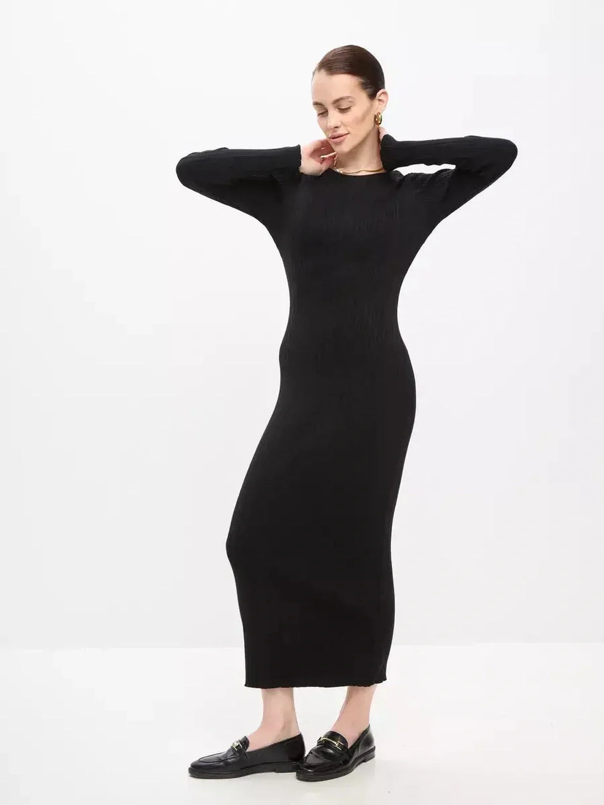 Model showcasing a Sculpted Rib Maxi Dress in black, featuring a streamlined silhouette and long sleeves, perfect for various occasions.