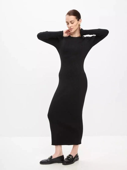 Model showcasing a Sculpted Rib Maxi Dress in black, featuring a streamlined silhouette and long sleeves, perfect for various occasions.