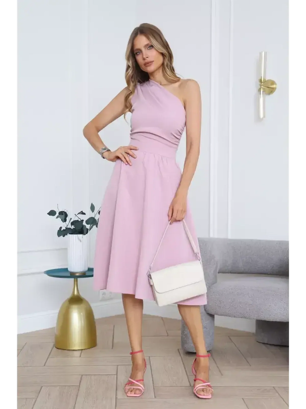 Model wearing a blush grace midi dress with one-shoulder design, styled for summer events or weddings.