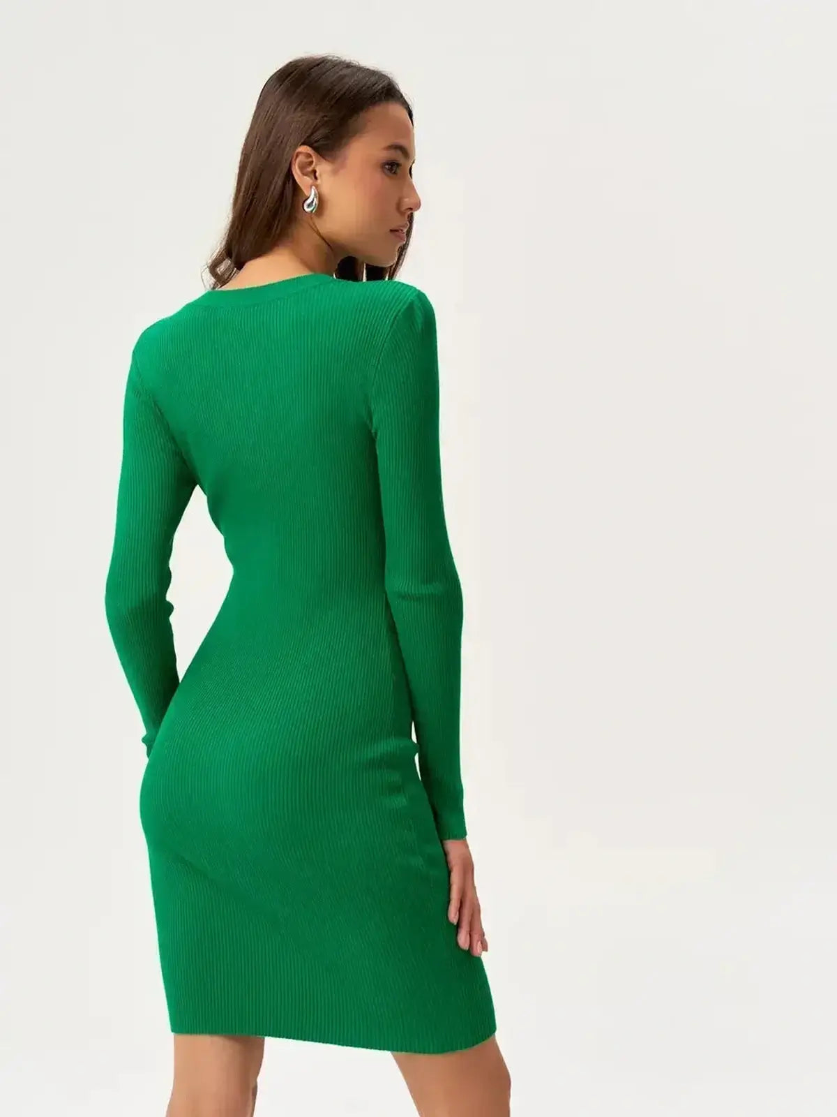Model showcasing a sleek jade green mini dress with long sleeves and a fitted silhouette.