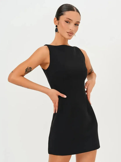 Model wearing a Jet Luxe Mini Dress, showcasing its sleek black silhouette and minimalist design, perfect for any occasion.