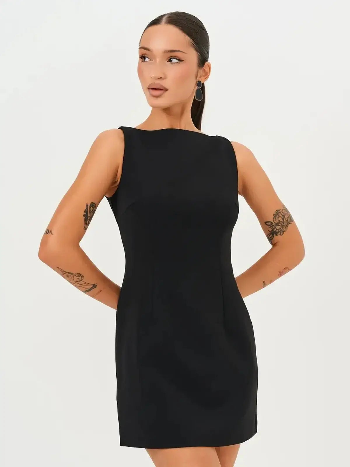 Model showcasing the Jet Luxe Mini Dress, a sleek black form-fitting mini dress with a round neckline.