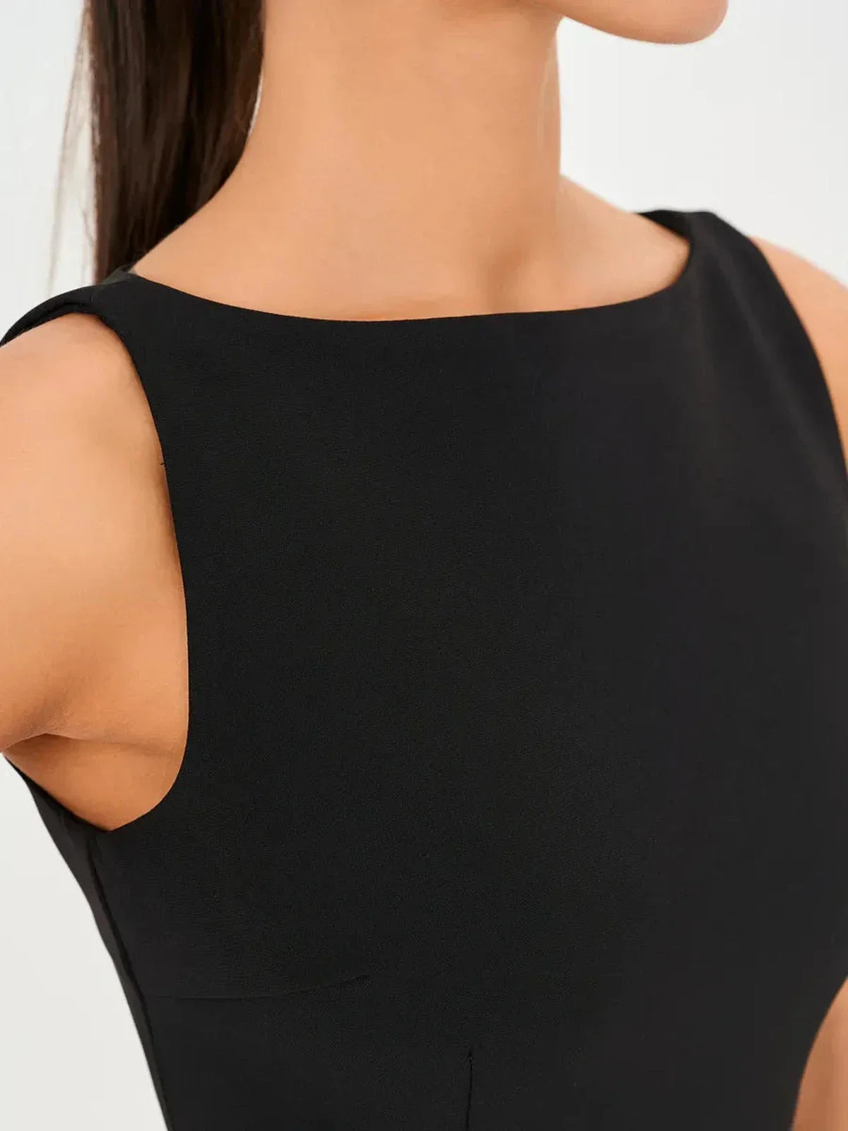 Close-up of the Jet Luxe Mini Dress featuring a sleek round neckline and form-fitting black design.