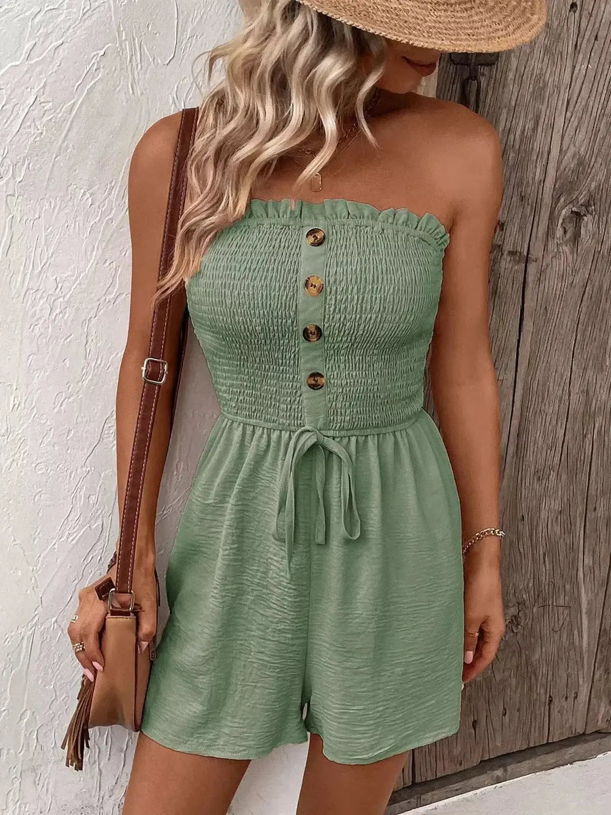 Woman wearing a green strapless mini dress with buttons and a tie waist, perfect for summer events and casual outings.