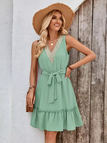 Model wearing a Lace Breeze Mini Dress in mint melange with a V-neckline, styled for summer outdoors.