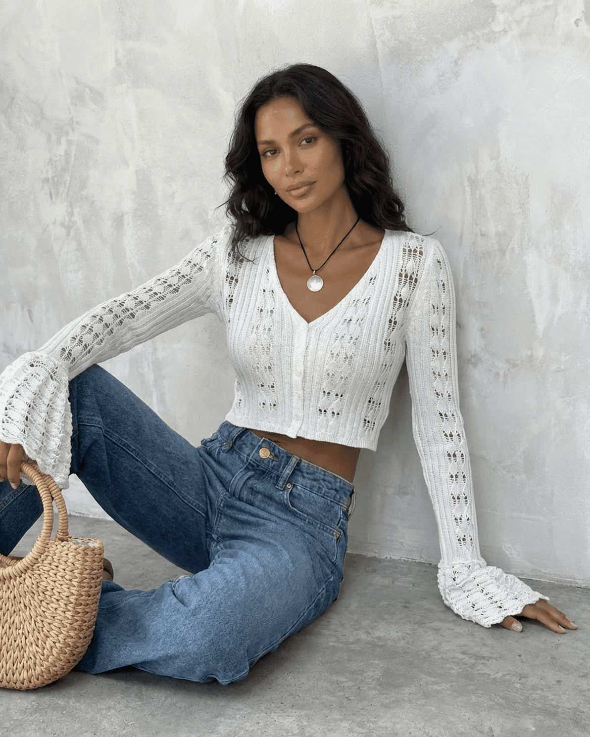 Model wearing a Laceflare Cardigan by Slimona, showcasing its elegant white cotton knit and flare sleeves.