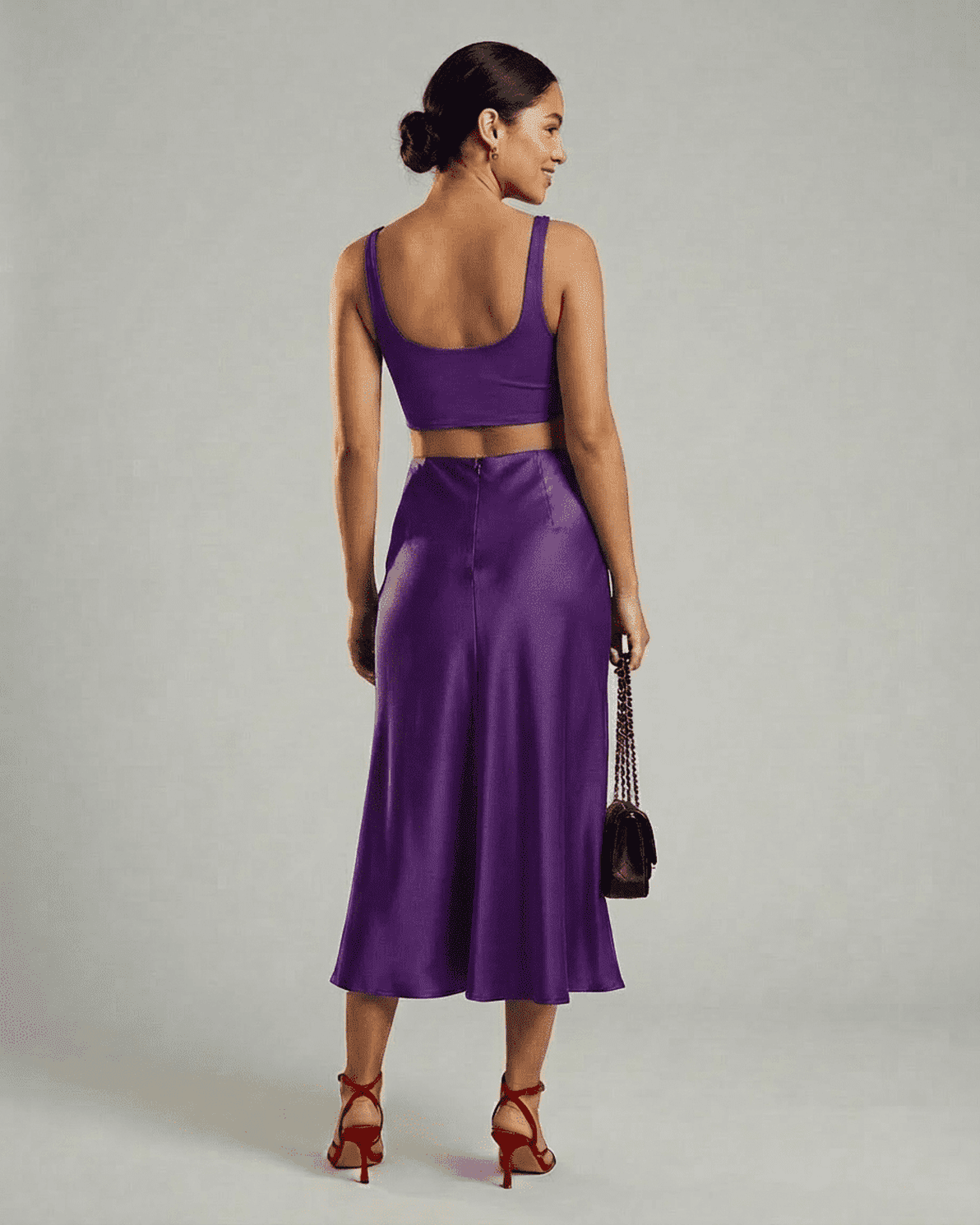 Back view of a model wearing the Slimona Amethyst Midi Skirt paired with a crop top.