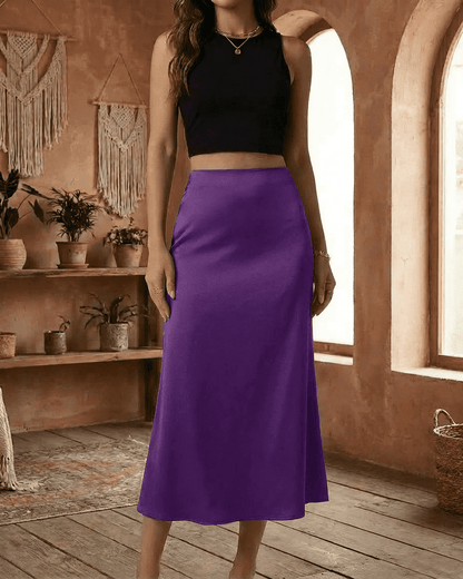 Model showcasing the Amethyst Midi Skirt by Slimona in vibrant purple satin, elegantly styled with a black crop top.
