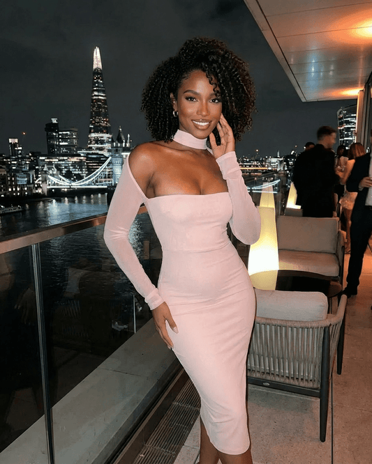 Arden Blush Dress by Slimona worn at night event with city skyline, featuring cutout long sleeves and bodycon fit.