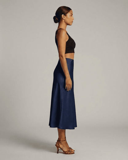 Astra Midi Skirt by Slimona in deep navy blue, showcasing elegant mermaid silhouette from side view.