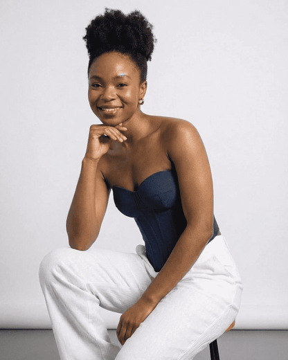 Model wearing the Atlas Corset Top by Slimona, a sleek navy faux denim bustier for a sophisticated look.