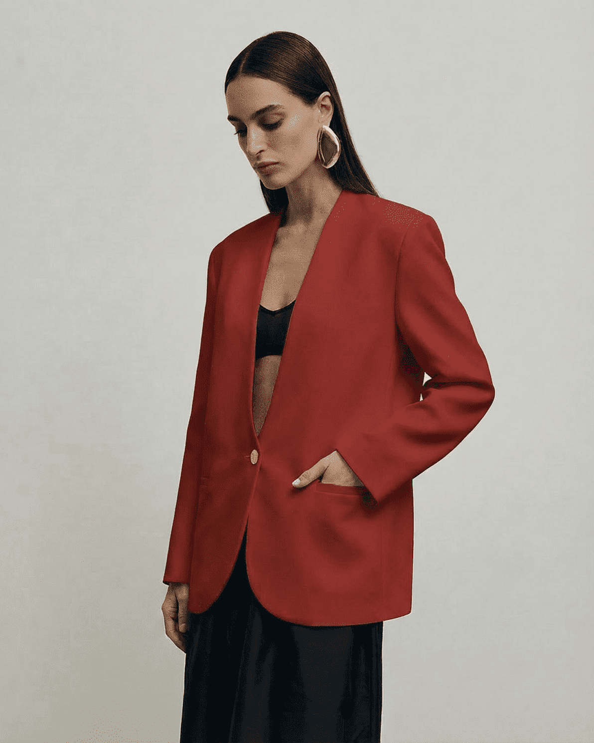 Carmine Blazer by Slimona worn by a model, showcasing its fitted silhouette and deep V-neckline in a rich red tone.