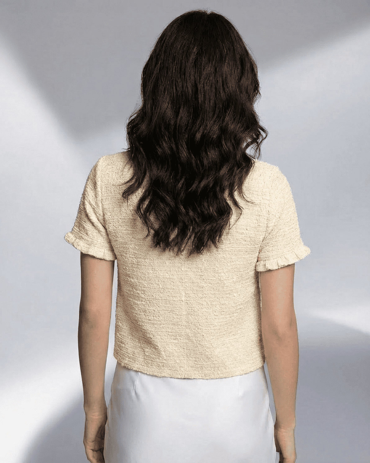 Back view of model wearing the Slimona Elara Cardigan, showcasing its short sleeves and textured knit design.