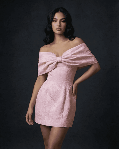 Fiora Mini Dress by Slimona featuring an elegant bowknot off-the-shoulder design in soft pink.