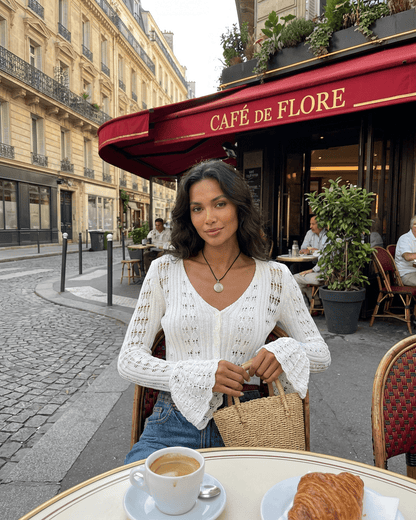 Laceflare Cardigan worn by a model at Café de Flore, featuring elegant lace details and flare sleeves.