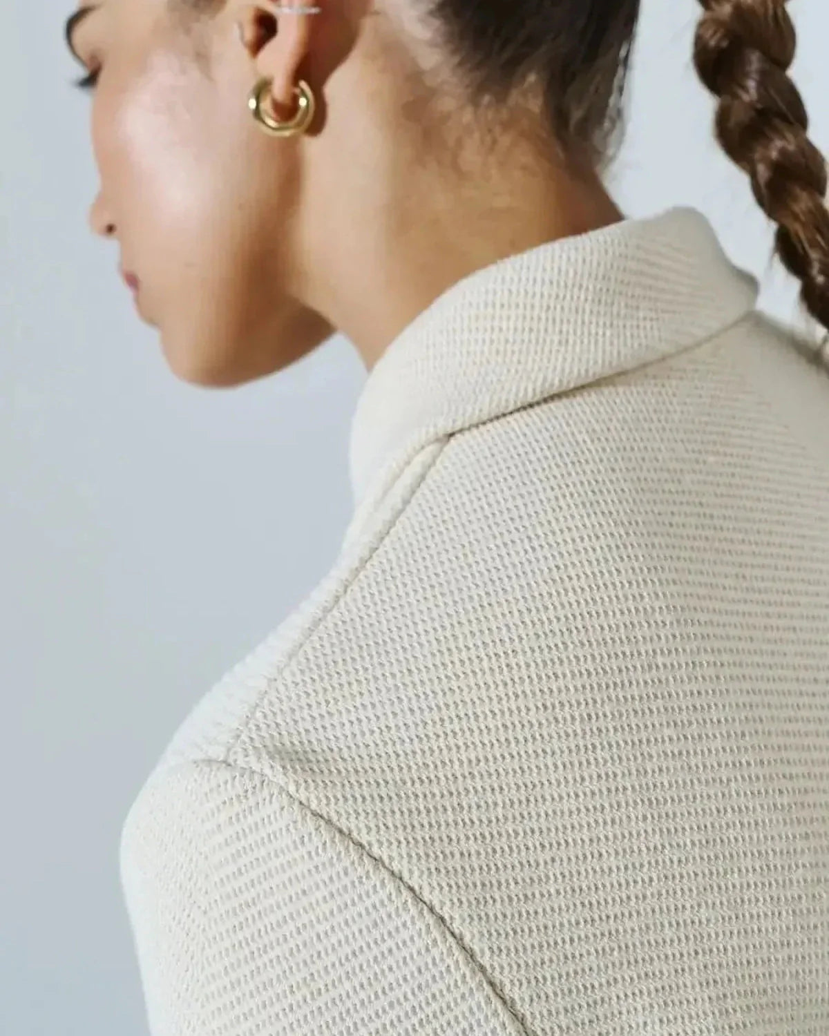 Close-up of a model wearing the Lazio Cropped Jacket by Slimona, showcasing its elegant cream fabric and tailored design.