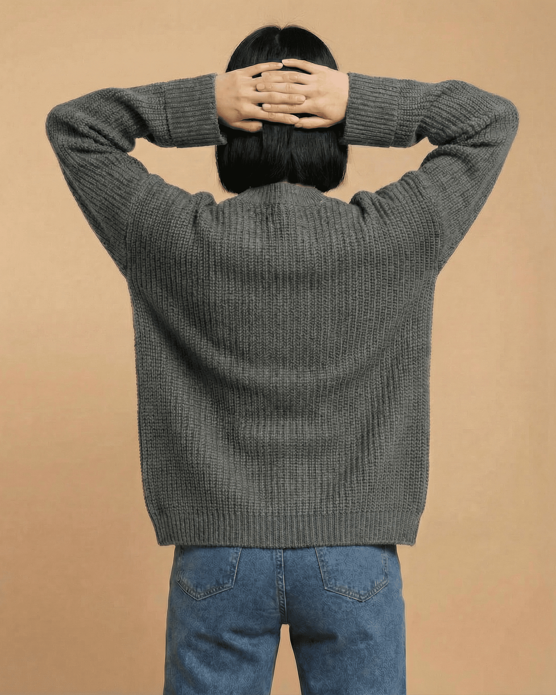 Back view of a woman wearing a relaxed fit gray Linden Cardigan from Slimona, showcasing its cozy knit design.