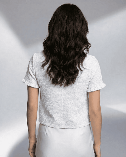 Back view of a model wearing the Slimona Luna Cardigan, showcasing its short sleeve and textured design.