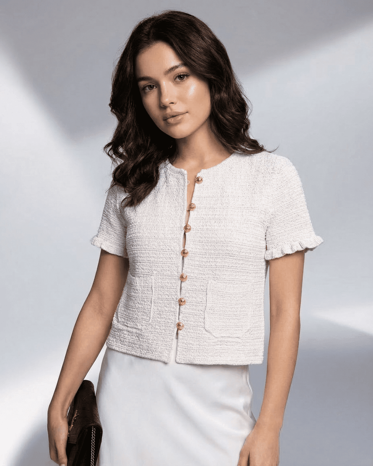 Model wearing Slimona's Luna Cardigan, a short sleeve button knitwear in textured fabric.