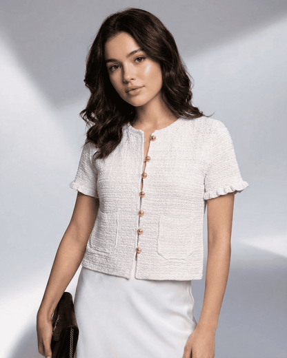 Model wearing Slimona's Luna Cardigan, a short sleeve button knitwear in textured fabric.