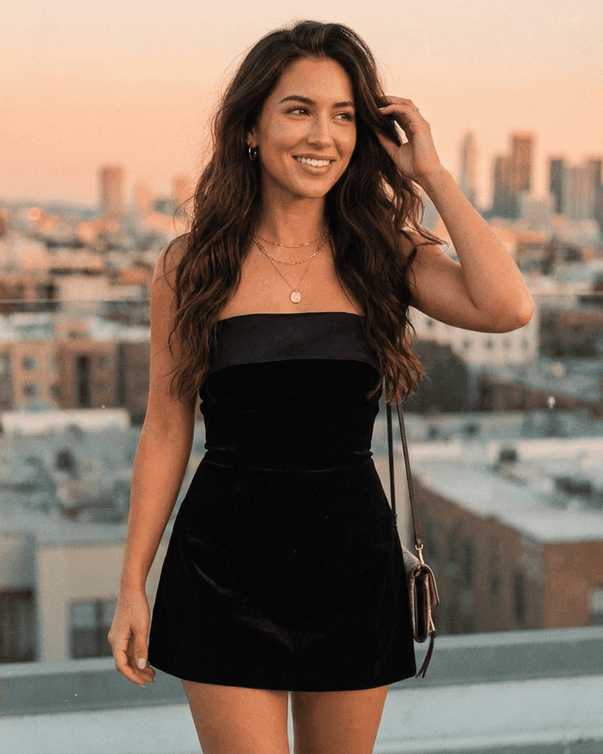Slimona Luxe Mini Dress showcased by a woman in a stunning velvet style against a city skyline.