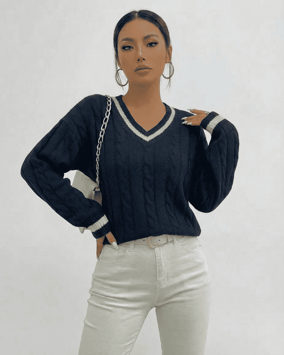 Marina Sweater by Slimona, a cable knit V-neck pullover worn with white jeans, showcasing style and comfort.