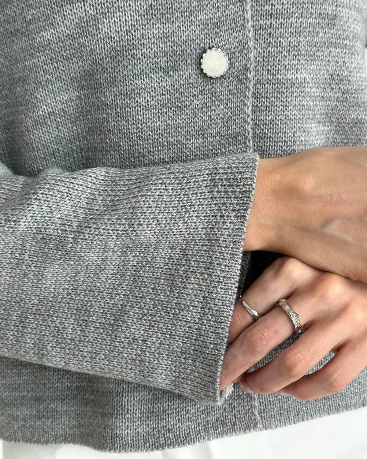 Detail of the Mist Cardigan by Slimona, showcasing cozy gray knit texture and button closure.