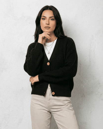 Noir Cardigan by Slimona – Stylish woman in a classic black cardigan with button detail and cozy fit.