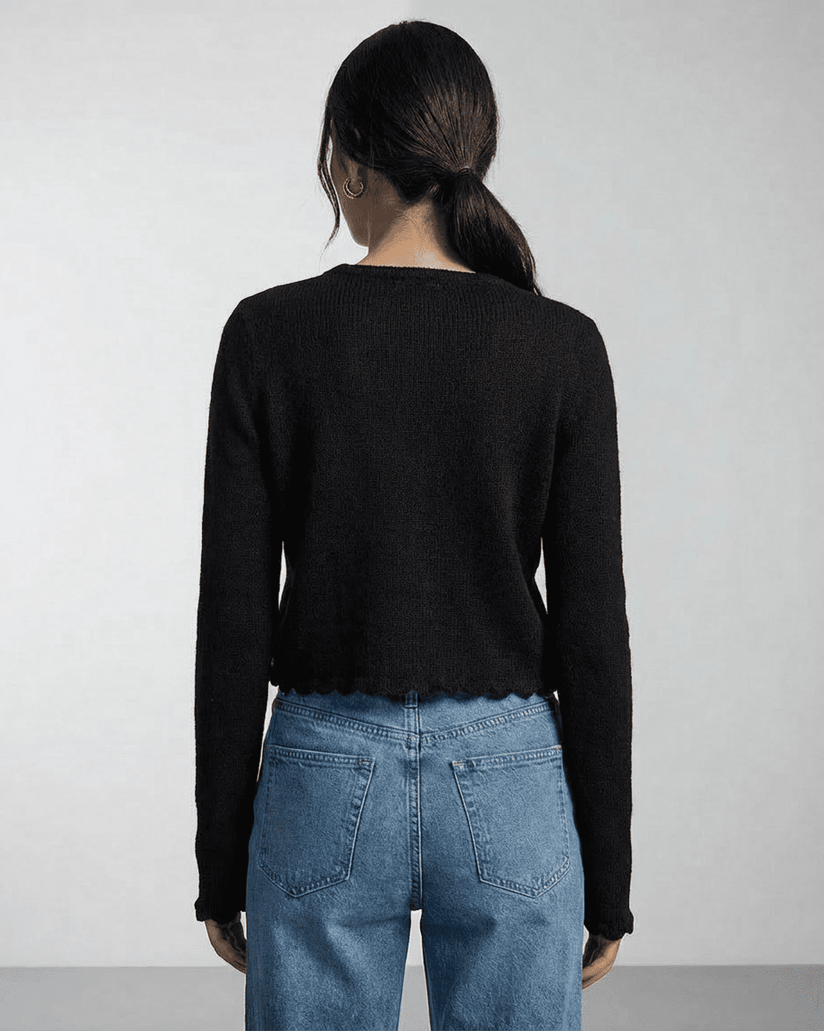 Back view of a woman wearing the Noir Cardigan by Slimona, showcasing its elegant and minimalist design.
