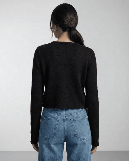 Back view of a woman wearing the Noir Cardigan by Slimona, showcasing its elegant and minimalist design.