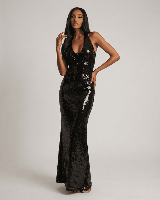 Noiré Maxi Dress by Slimona features a backless V-neck silhouette with floral sequin detail and a shimmering black finish.