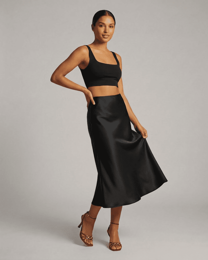Noirelle Midi Skirt from Slimona displayed on a model, showcasing the sleek satin mermaid design in classic black.