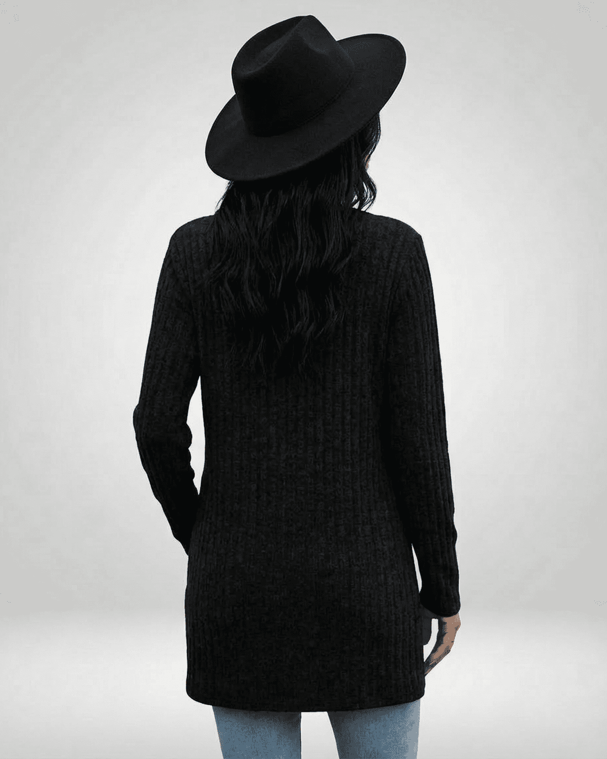 Back view of a woman in a longline Nyx Cardigan by Slimona, featuring a textured knit and a black hat.