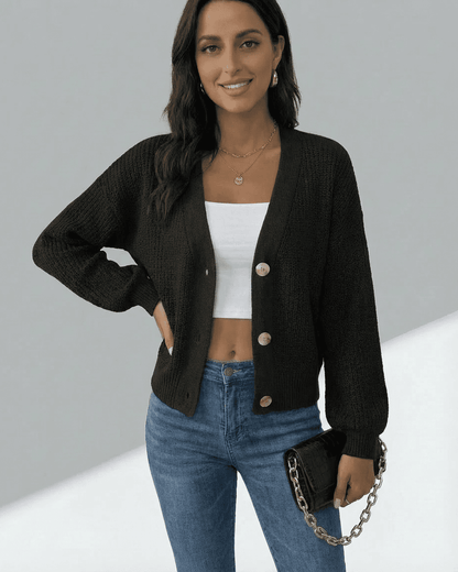 Model wearing Slimona Orion Cardigan, a stylish long sleeve V-neck knitwear in black, paired with jeans.