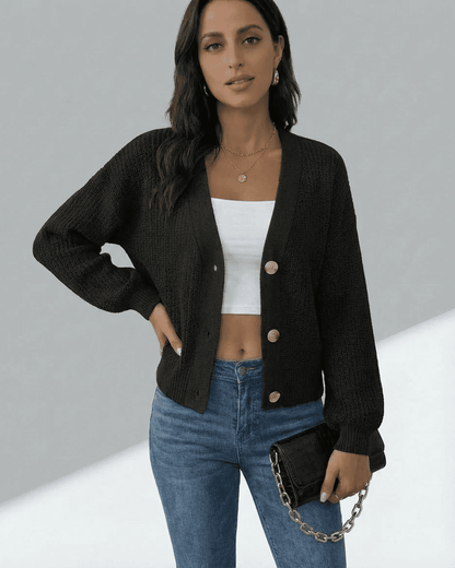 Model wearing the Slimona Orion Cardigan with a V-neckline, paired with jeans and a clutch.