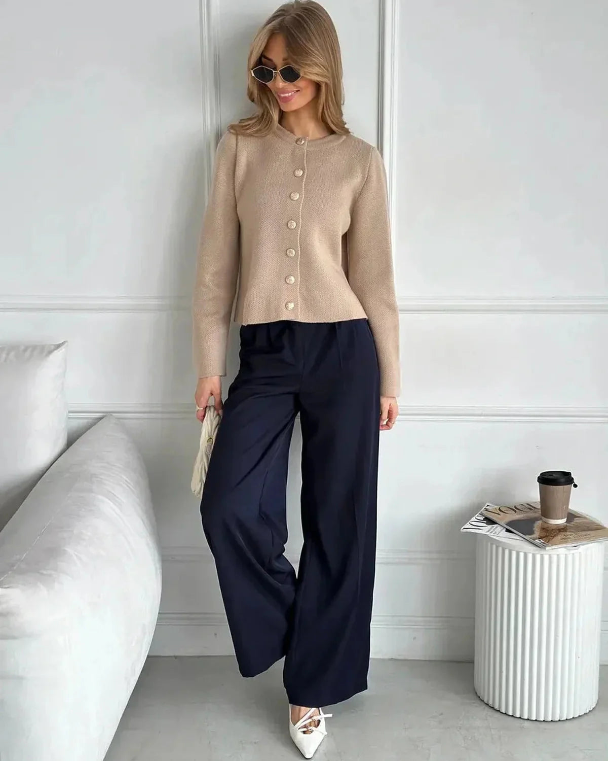 Sable Cardigan by Slimona, elegant cropped knitwear in beige, styled with navy pants and sunglasses.