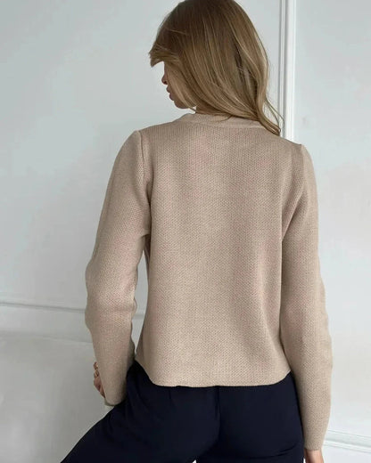 Back view of a woman wearing the Sable Cardigan by Slimona, showcasing its elegant beige cropped design.