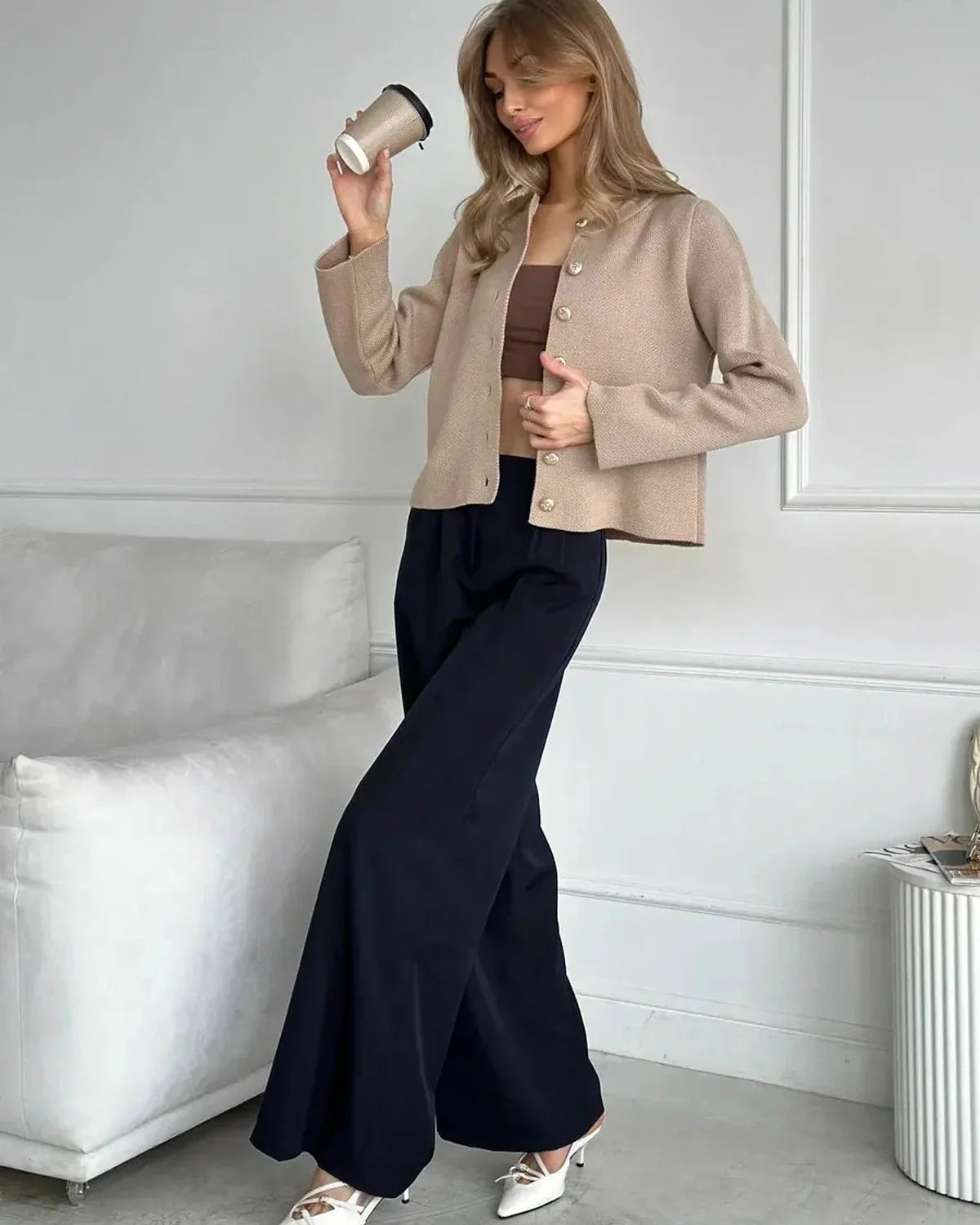 Elegant woman wearing Sable Cardigan from Slimona, styled with wide-leg pants, holding a coffee cup.