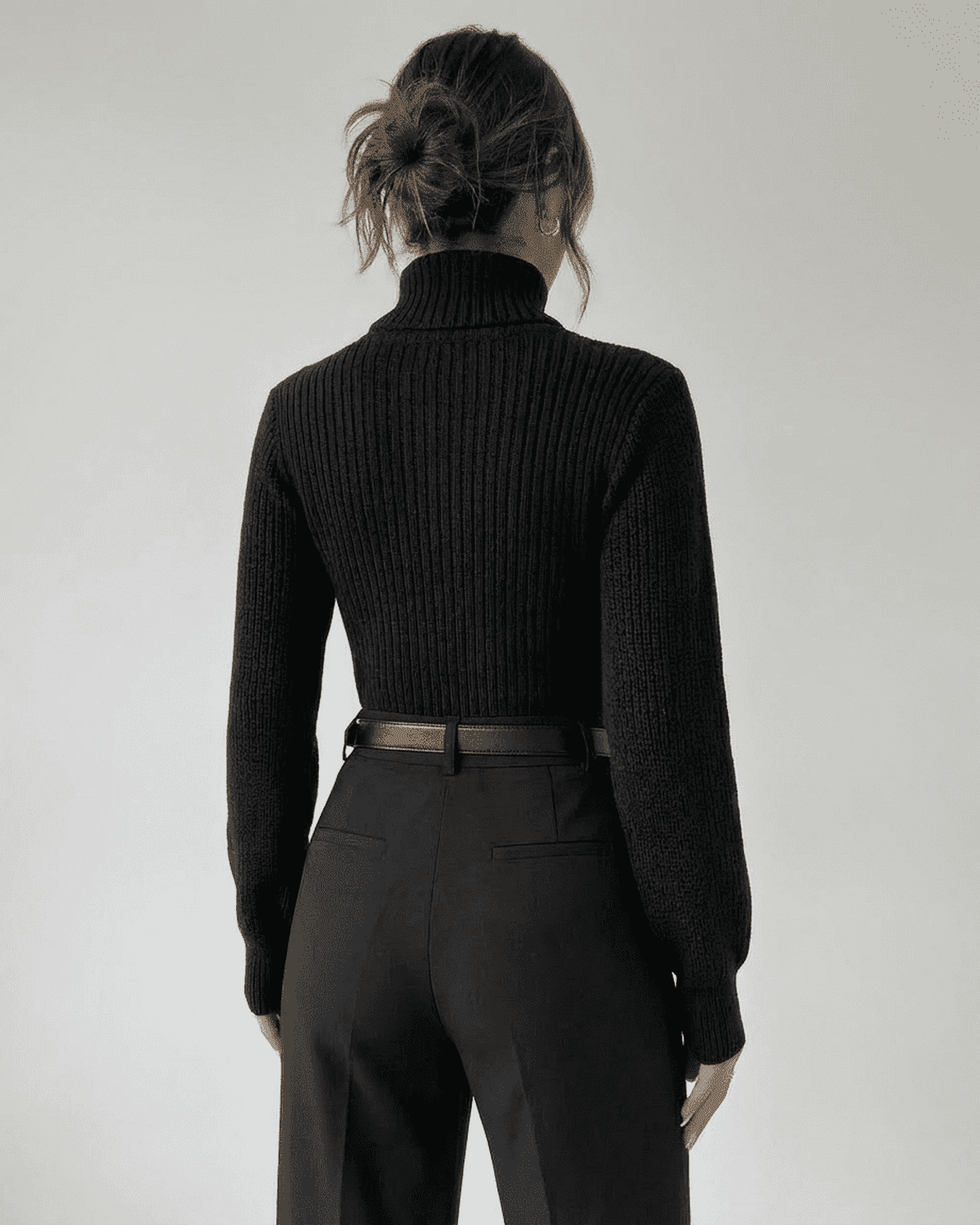 Woman wearing the Sarina Sweater by Slimona, showcasing the back view with a mock neck and ribbed texture.